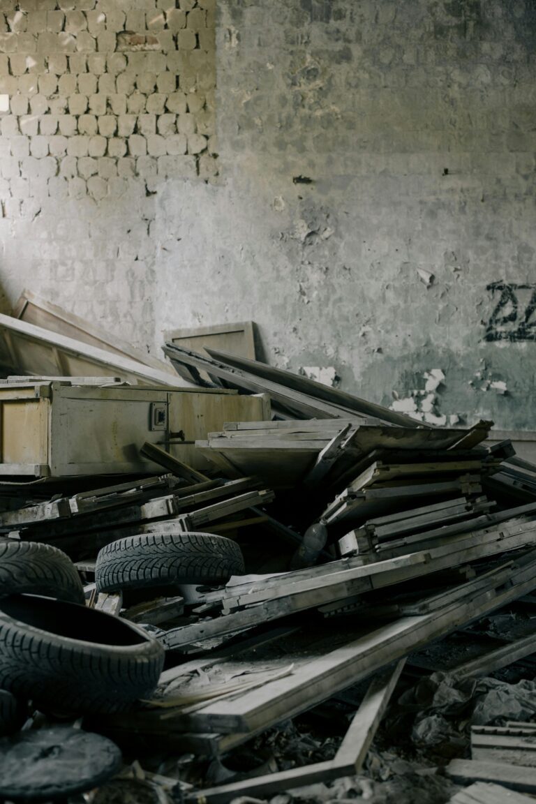 A cluttered abandoned room with broken furniture and old tires, symbolizing neglect and decay.